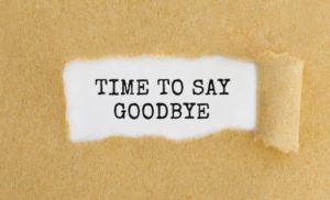 Text Time To Say Goodbye appearing behind ripped brown paper.